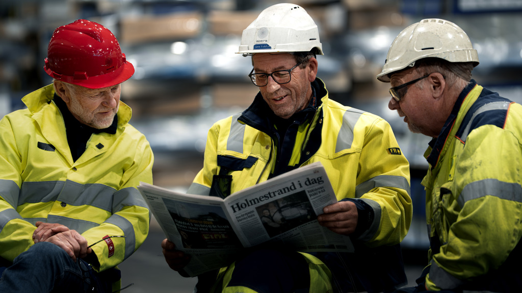 Three colleagues reading a newspaper
